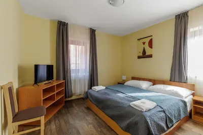 a bedroom with a bed and a tv and a chair at Hotel STARÝ PIVOVAR in Prague