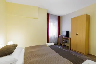 a bedroom with a bed and a desk with a television at Hotel STARÝ PIVOVAR in Prague