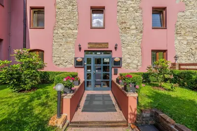 a pink building with a blue door at Hotel STARÝ PIVOVAR in Prague