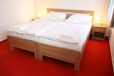 a bedroom with a large bed with white sheets at Penzion U sv. Kryštofa in Prague