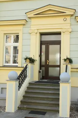 a yellow house with stairs and a door at Penzion U sv. Kryštofa in Prague