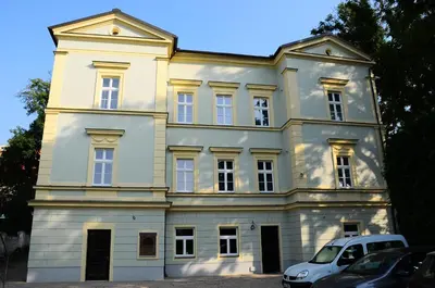 a white house with a car parked in front of it at Penzion U sv. Kryštofa in Prague