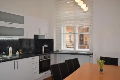a kitchen with white cabinets and a wooden table at Tiva Downtown Apartments in Prague