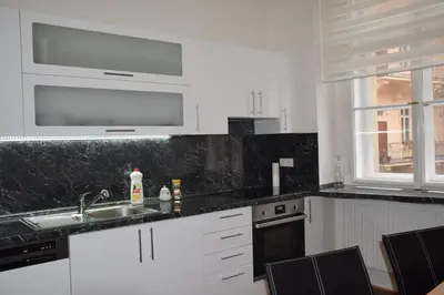 a kitchen with white cabinets and black counter tops at Tiva Downtown Apartments in Prague