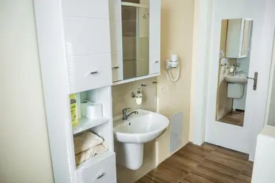 a white bathroom with a sink and a mirror at Villa A. Malka in Poděbrady