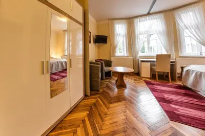 a room with a bed and a table and a desk at Villa A. Malka in Poděbrady