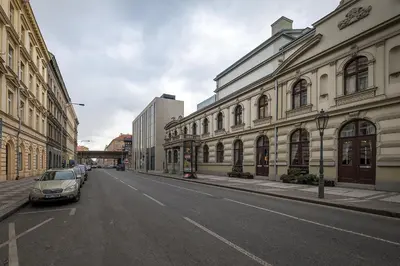 an empty street with cars parked in front of buildings at Prague Days - Family Friendly Three-bedroom Apartment in trendy Karlín in Prague