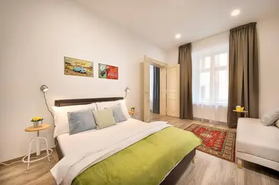 a white living room with a table and a couch at Prague Days - Family Friendly Three-bedroom Apartment in trendy Karlín in Prague
