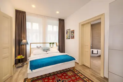 a bedroom with a bed with a dresser and a mirror at Prague Days - Family Friendly Three-bedroom Apartment in trendy Karlín in Prague