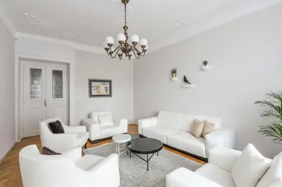 a living room with white furniture and a chandelier at Art Nouveau Residence in Prague