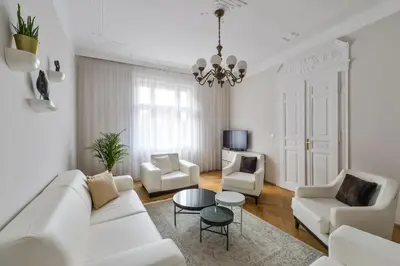 a living room with white furniture and a chandelier at Art Nouveau Residence in Prague