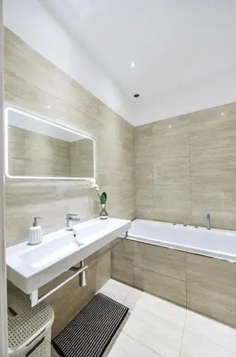 a bathroom with a tub and a sink and a mirror at Art Nouveau Residence in Prague