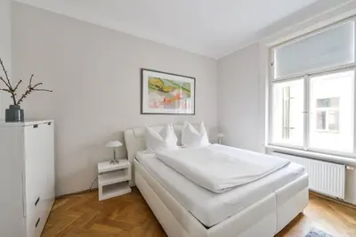 a white bedroom with a white bed and a window at Art Nouveau Residence in Prague