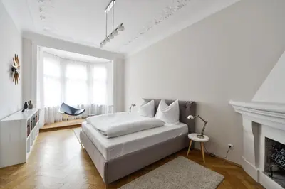 a white bedroom with a bed and a fireplace at Art Nouveau Residence in Prague