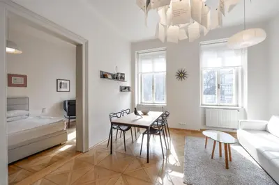 a living room with a table and chairs and a couch at Kafka's Head Apartment in Prague