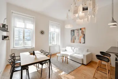 a living room with a white couch and a table at Kafka's Head Apartment in Prague
