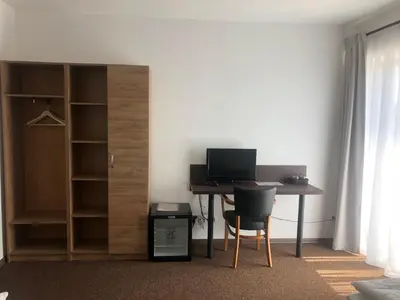 a room with a desk with a computer and a closet at Motel R10 in Mladá Boleslav