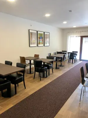 a dining room with tables and chairs and a rug at Motel R10 in Mladá Boleslav