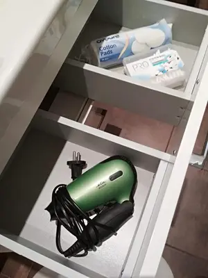 a green hairdryer on a shelf in a drawer at Cozy Private Apartment in Prague