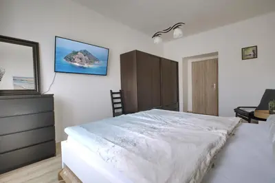 a bedroom with a large white bed and a dresser at Cozy Private Apartment in Prague