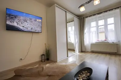 a living room with a tv on the wall at Cozy Private Apartment in Prague