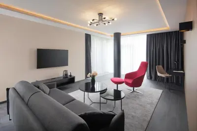 a living room with a couch and red chairs at Spa Hotel Felicitas in Poděbrady