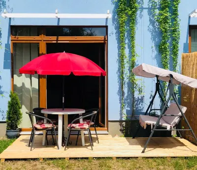 a table and two chairs and a red umbrella on a deck at Maria Apartments - Free Parking in Prague