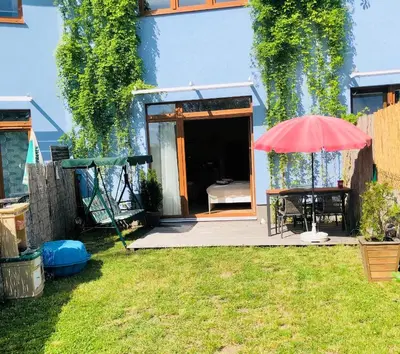 a patio with a table and an umbrella in a yard at Maria Apartments - Free Parking in Prague