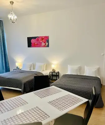 a bedroom with two beds and a table and a picture at Maria Apartments - Free Parking in Prague