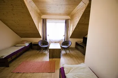 a room with a bed and two chairs and a table at Penzion Na Americe in Nové Jirny