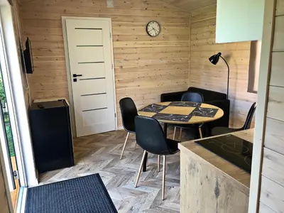 a room with a table and chairs and a clock at Penzion Na Americe in Nové Jirny