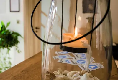 a candle in a glass vase with shells in it at Penzion Na Americe in Nové Jirny