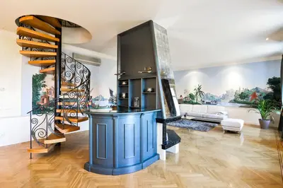 a living room with a staircase and a blue island at Panoramic Loft in Prague