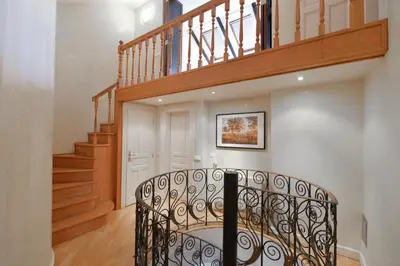 a spiral staircase in a home with a wooden stair case at Panoramic Loft in Prague
