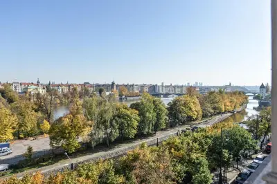 a view of a river with trees and a city at Panoramic Loft in Prague