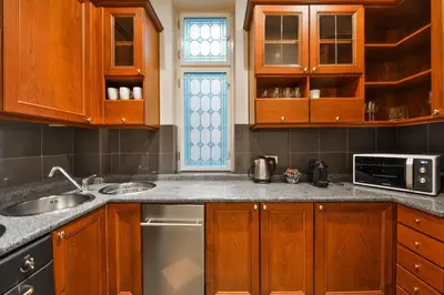 a kitchen with wooden cabinets and a sink at Panoramic Loft in Prague