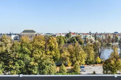 a view of a city with a river and trees at Panoramic Loft in Prague