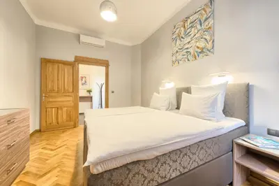 a bedroom with a large white bed and a wooden floor at Spacious And Bright Apartment Dusni 13 in Prague