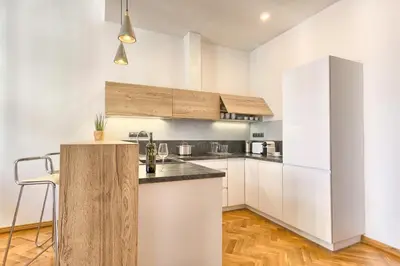 a kitchen with white cabinets and a counter top at Spacious And Bright Apartment Dusni 13 in Prague