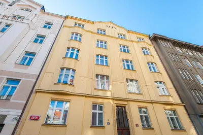 a yellow building with many windows on a street at Spacious And Bright Apartment Dusni 13 in Prague