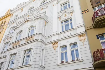a white building with windows on a street at Trendy Local Apartment in Prague
