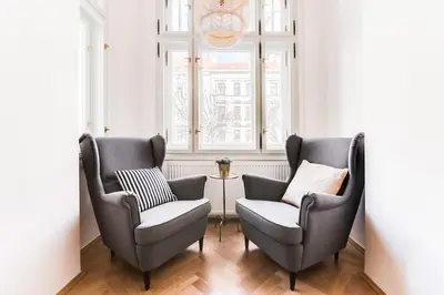 two chairs and a table in a room with a window at Trendy Local Apartment in Prague