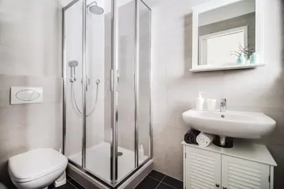 a bathroom with a shower and a toilet and a sink at Trendy Local Apartment in Prague
