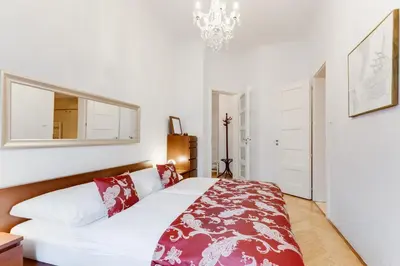 a bedroom with a large white bed with red pillows at Old Town Square Royal Apartment in Prague