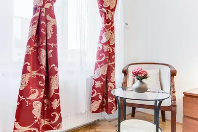 a vase of flowers on a table next to a window at Old Town Square Royal Apartment in Prague