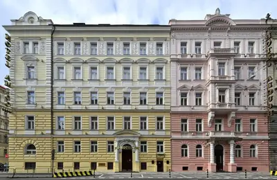a large yellow and pink building at Alqush Downtown Hotel in Prague