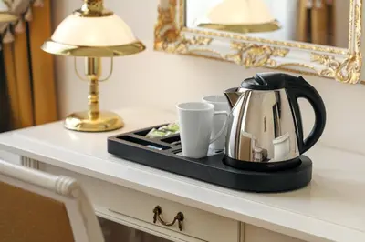 a tea kettle and cups on a tray on a table at Alqush Downtown Hotel in Prague