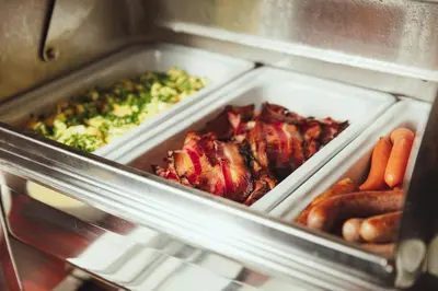 a refrigerator with two trays of food and vegetables at Alqush Downtown Hotel in Prague