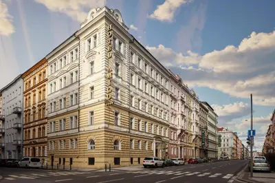 a large white building on the side of a street at Alqush Downtown Hotel in Prague