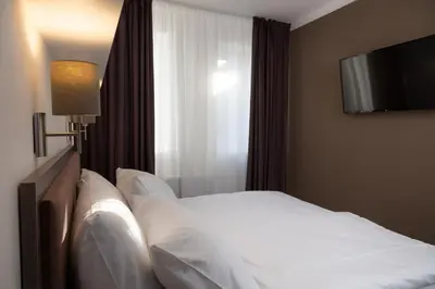 a bedroom with a bed with a television on the wall at Skyhotel Prague in Prague